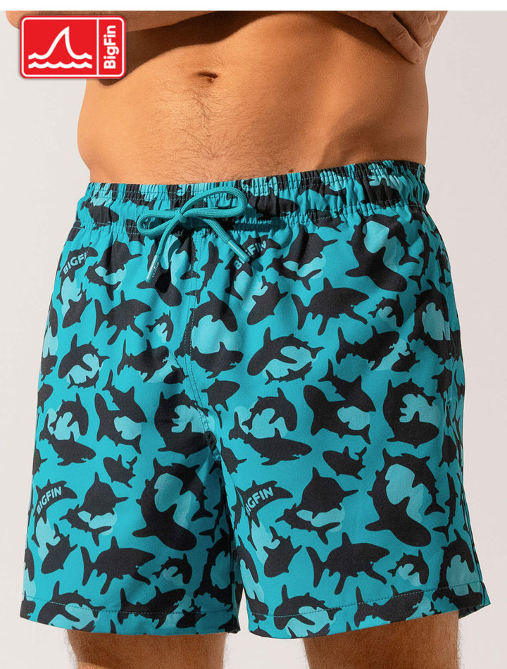 Blue camouflage swim shorts with a visible brand logo on a white background