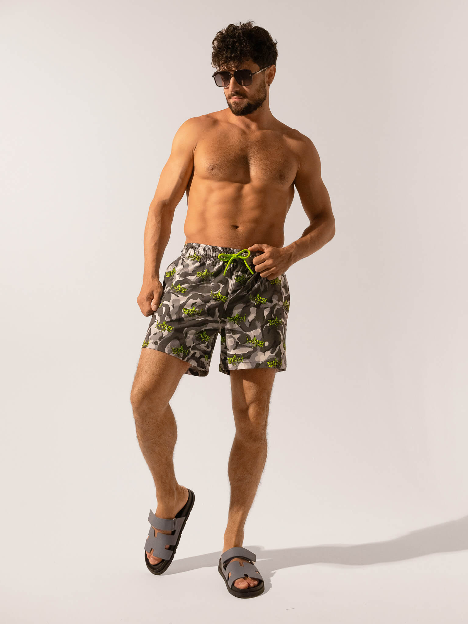 Man wearing camouflage swim shorts on a white background