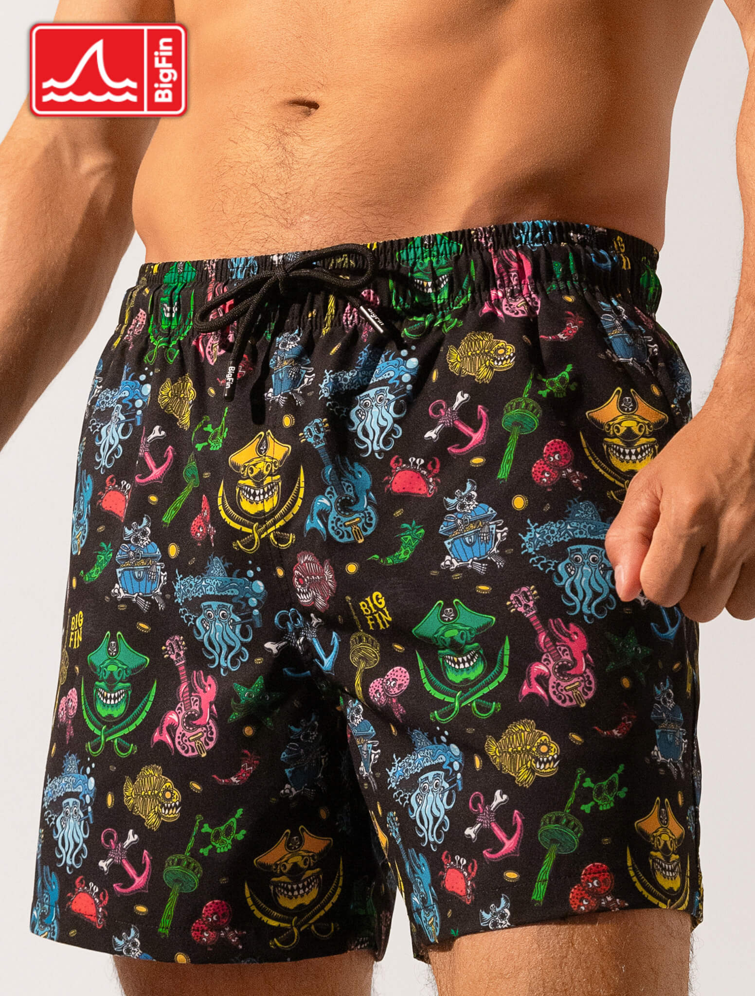 Colorful patterned swim shorts with a visible brand logo on a plain background